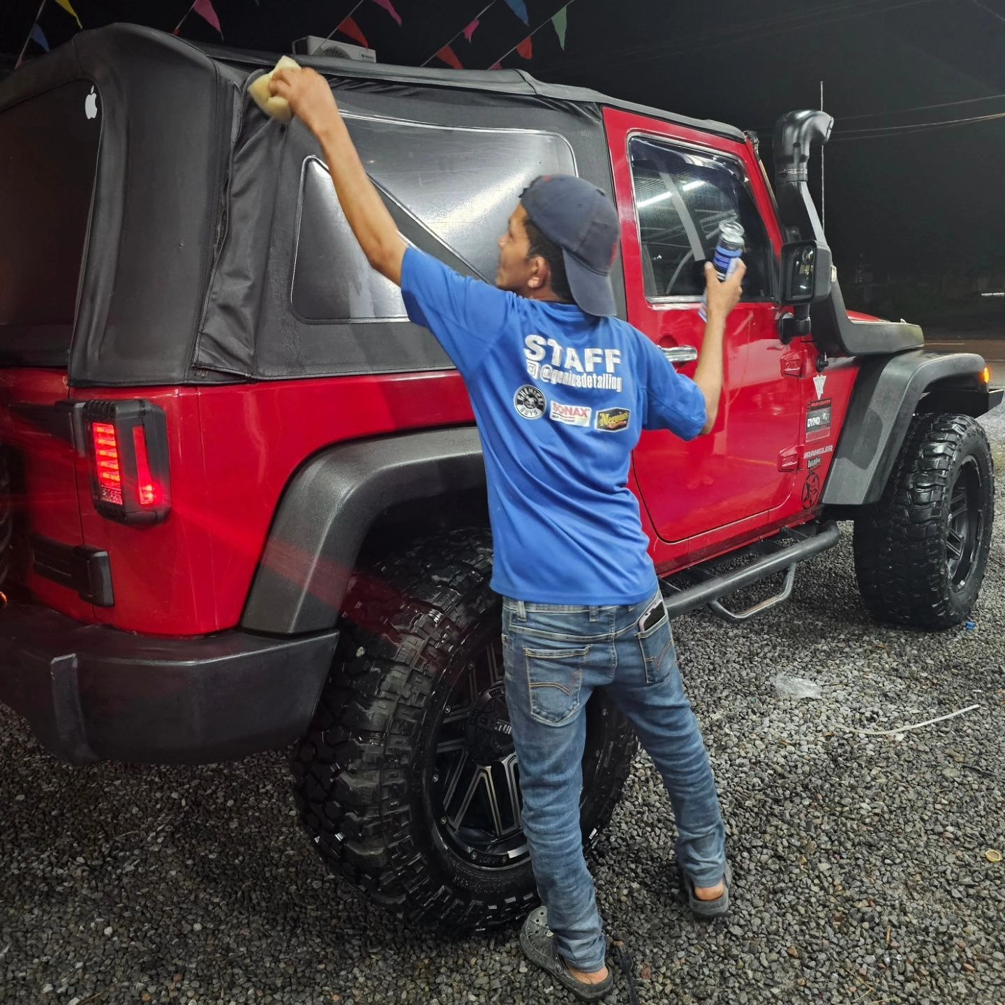 Personal de Deluxe CW cuidando los acabados de un Jeep rojo